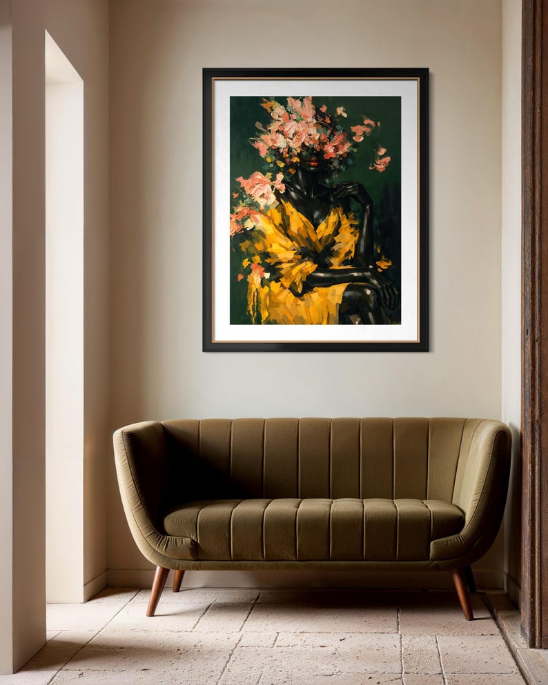 Puede incluir: Una impresi&oacute;n art&iacute;stica enmarcada que presenta a una mujer con un tocado floral y un vestido amarillo. La obra de arte tiene un fondo verde oscuro y se exhibe sobre un sof&aacute; de terciopelo verde con patas de madera. La habitaci&oacute;n tiene una paleta de colores neutros.