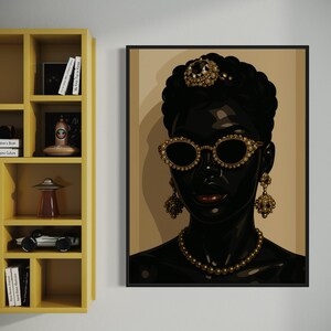 May include: A framed art print featuring a stylized portrait of a person with dark skin. The person is adorned with gold-colored jewelry, including a necklace, earrings, sunglasses, and a headpiece. The background is a neutral beige.