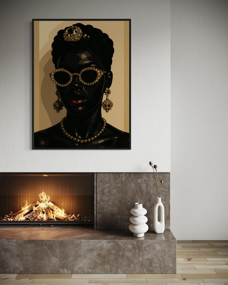 May include: A framed art print featuring a stylized portrait of a person with dark skin. The person wears gold-rimmed sunglasses, a jeweled headpiece, earrings, and a necklace. The artwork is set against a neutral background.
