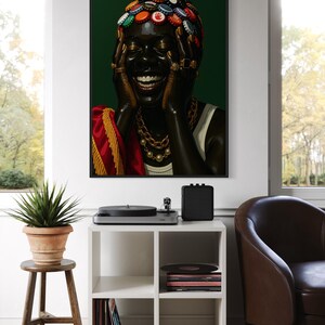 May include: A framed portrait of a person with dark skin, adorned with bottle caps on their head and gold jewelry. The person is smiling with hands on their face. The background is a dark green.