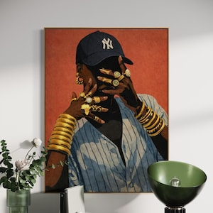 May include: Framed art print featuring a person wearing a navy blue baseball cap with a white "NY" logo. The person is adorned with numerous gold rings and bracelets, and a blue and white striped shirt. The background is a solid red.