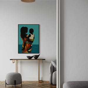 May include: A framed art print depicts a silhouette of a person holding a child, set against a teal background with a water-like design. The person's clothing features a colorful pattern of red, orange, and yellow.