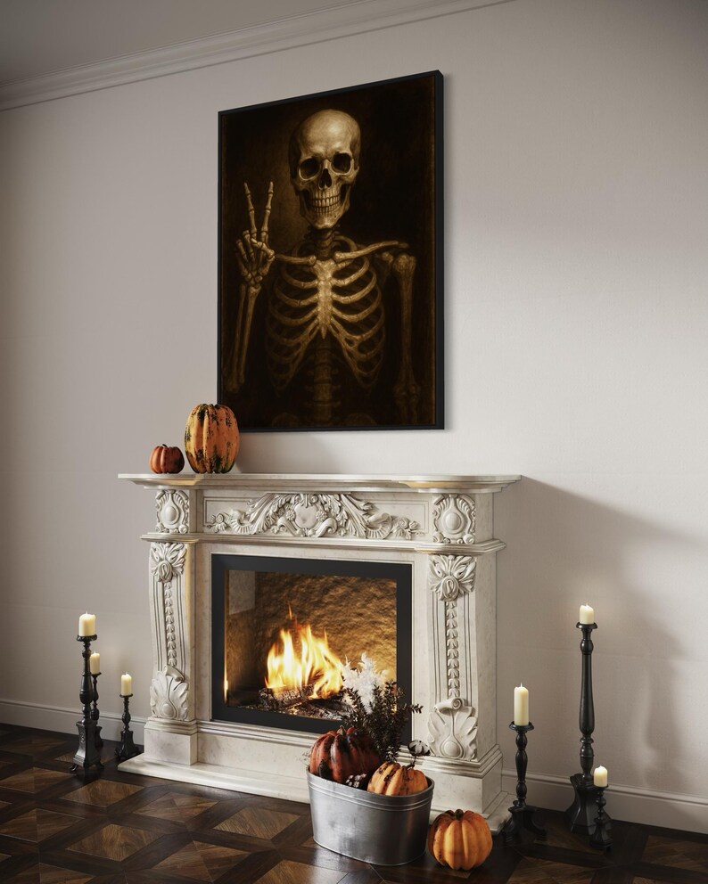 Puede incluir: Una obra de arte enmarcada representa un esqueleto haciendo el signo de la paz. Cuelga sobre una chimenea de m&aacute;rmol blanco con fuego. Calabazas y velas decoran la chimenea, creando un tema de Halloween.