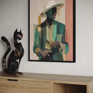 May include: Framed art print featuring a stylized portrait of a person in a green blazer, striped shirt, and white hat. The artwork has a geometric design with a drink in hand. The art is displayed above a wooden cabinet with a black cat sculpture.