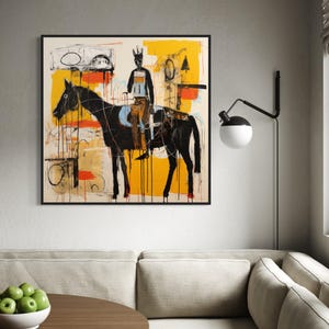 May include: Abstract artwork depicting a black horse and rider against a yellow and white backdrop. The painting, with its bold brushstrokes and minimalist style, is framed in black. It's displayed on a grey wall.