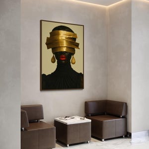 May include: An artistic portrait of a person with dark skin, red lips, and gold earrings. The person's eyes are covered by layered gold bands. The portrait is in a brown frame, hanging above two brown leather chairs and a marble-topped table.