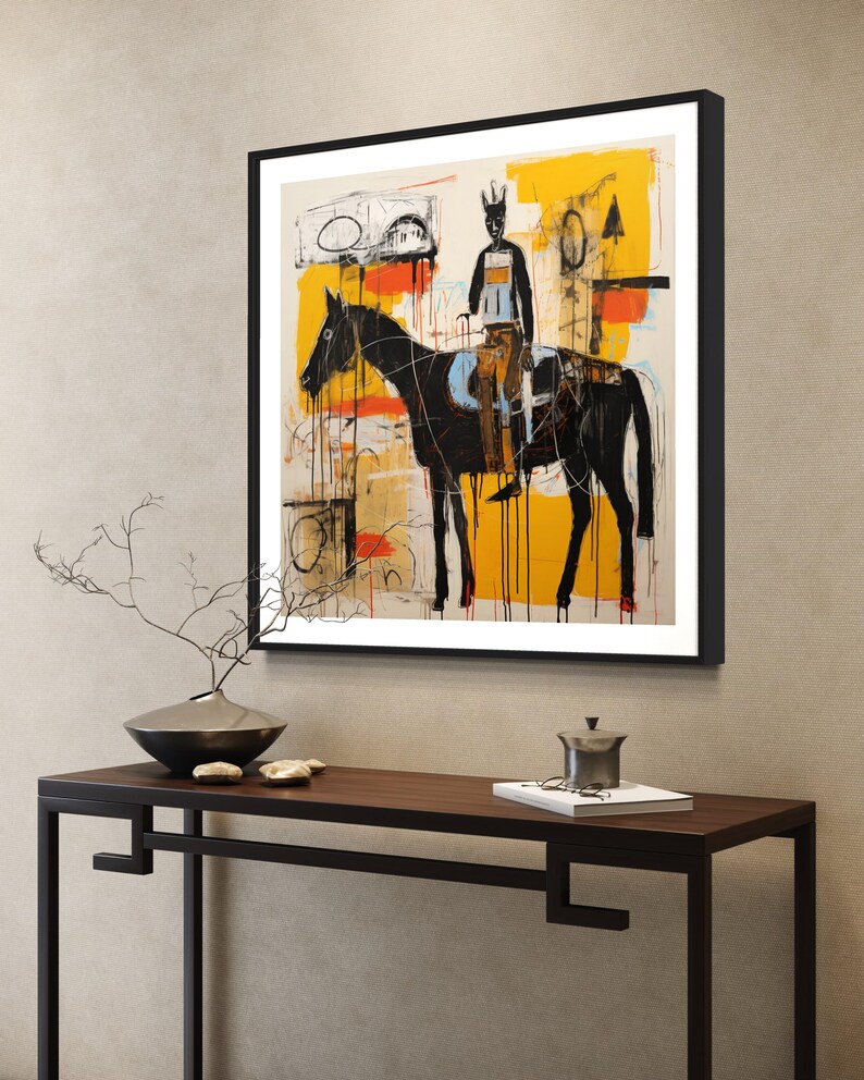 May include: Abstract art print depicting a black horse and rider, set against a backdrop of yellow, orange, and white brushstrokes. The artwork is framed in a black frame and displayed on a wall.
