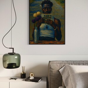 Puede incluir: Impresi&oacute;n art&iacute;stica enmarcada que presenta un retrato de una persona sosteniendo un libro con el texto "BLACK IS BEAUTIFUL". La obra de arte incluye un jarr&oacute;n con flores y est&aacute; ambientada en un fondo de carretera. La impresi&oacute;n se muestra encima de una mesita de noche blanca.