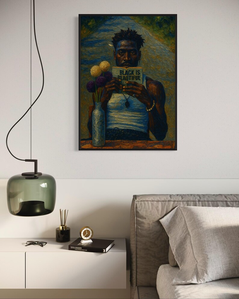 Puede incluir: Impresi&oacute;n art&iacute;stica enmarcada que presenta un retrato de una persona sosteniendo un libro con el texto "BLACK IS BEAUTIFUL". La obra de arte incluye un jarr&oacute;n con flores y est&aacute; ambientada en un fondo de carretera. La impresi&oacute;n se muestra encima de una mesita de noche blanca.