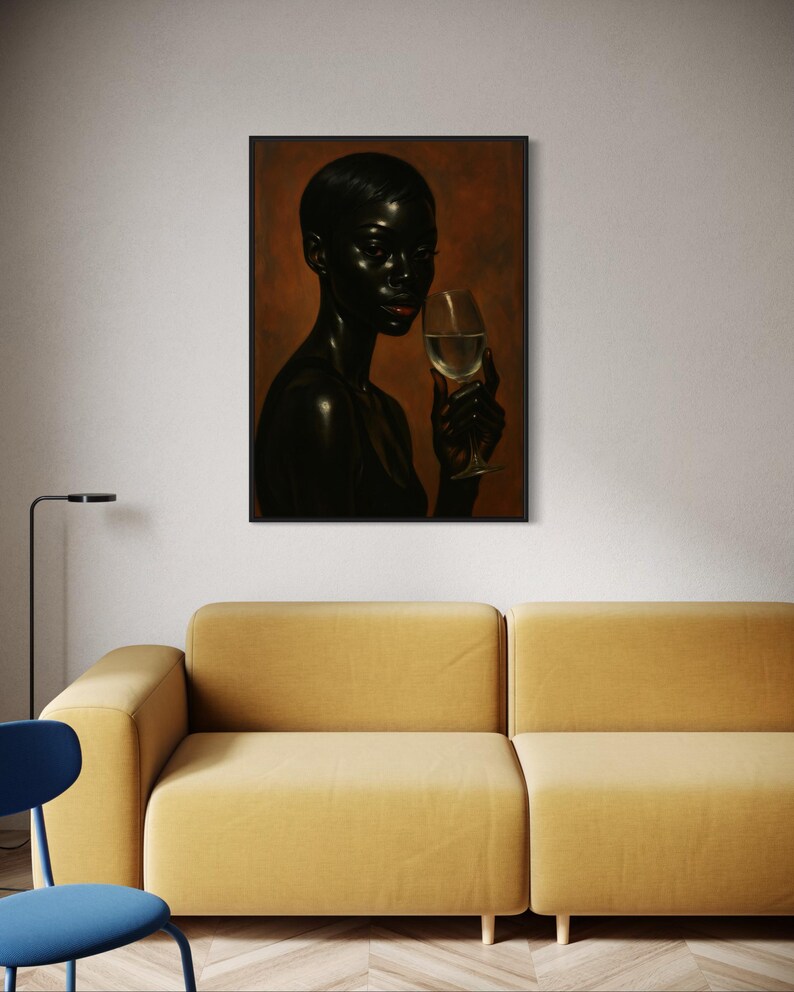 May include: A framed portrait of a person with dark skin holding a glass of white wine. The person is depicted with short hair and red lipstick. The background is a warm, reddish-brown color. The portrait hangs above a yellow sofa.