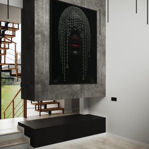 Pode incluir: Uma obra de arte emoldurada com um retrato de uma pessoa com pele escura, adornada com um adorno de cabe&ccedil;a de cristal e l&aacute;bios vermelhos. A obra de arte &eacute; montada em uma estrutura de concreto cinza escuro, com um banco preto abaixo. O ambiente interno inclui uma escada e ilumina&ccedil;&atilde;o moderna.