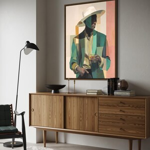 May include: A framed art print depicts a person in a white hat and green blazer holding a glass. The artwork hangs above a wooden sideboard with sliding doors and drawers. A black lamp and chair are in the foreground.