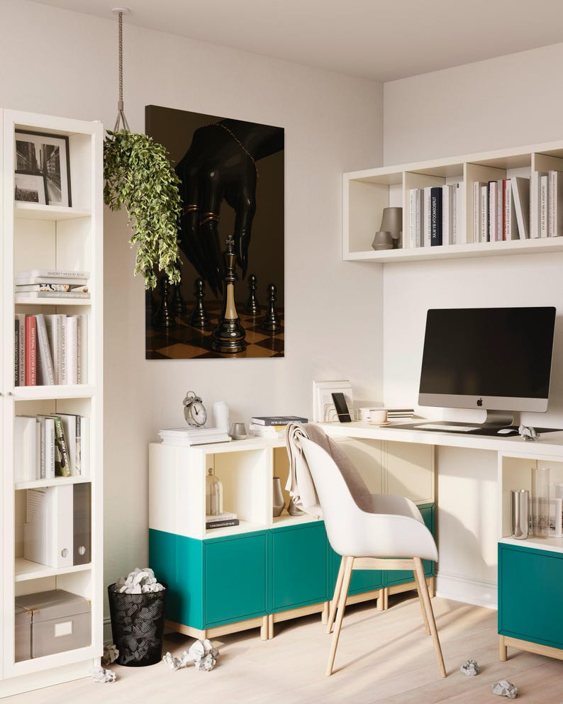Op de afbeelding: Een moderne thuiskantoor met witte meubels, een turquoise kast en een computer. Een kunstwerk met schaakthema hangt aan de muur. Een hangplant en een zwarte prullenbak voegen decoratieve elementen toe. De kamer is goed verlicht en georganiseerd.