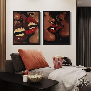 Pu&ograve; includere: Due stampe incorniciate in bianco e nero di labbra di coppia, con rossetto rosso, che si baciano. Le stampe sono appese a un muro sopra un divano con una coperta e cuscini.