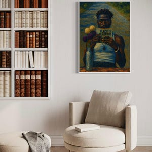 Puede incluir: Una impresi&oacute;n art&iacute;stica enmarcada que presenta un retrato de una persona sosteniendo un letrero que dice "BLACK IS BEAUTIFUL". La obra de arte incluye un jarr&oacute;n con flores y se exhibe sobre un sill&oacute;n beige. En el fondo se ve una estanter&iacute;a llena de libros.