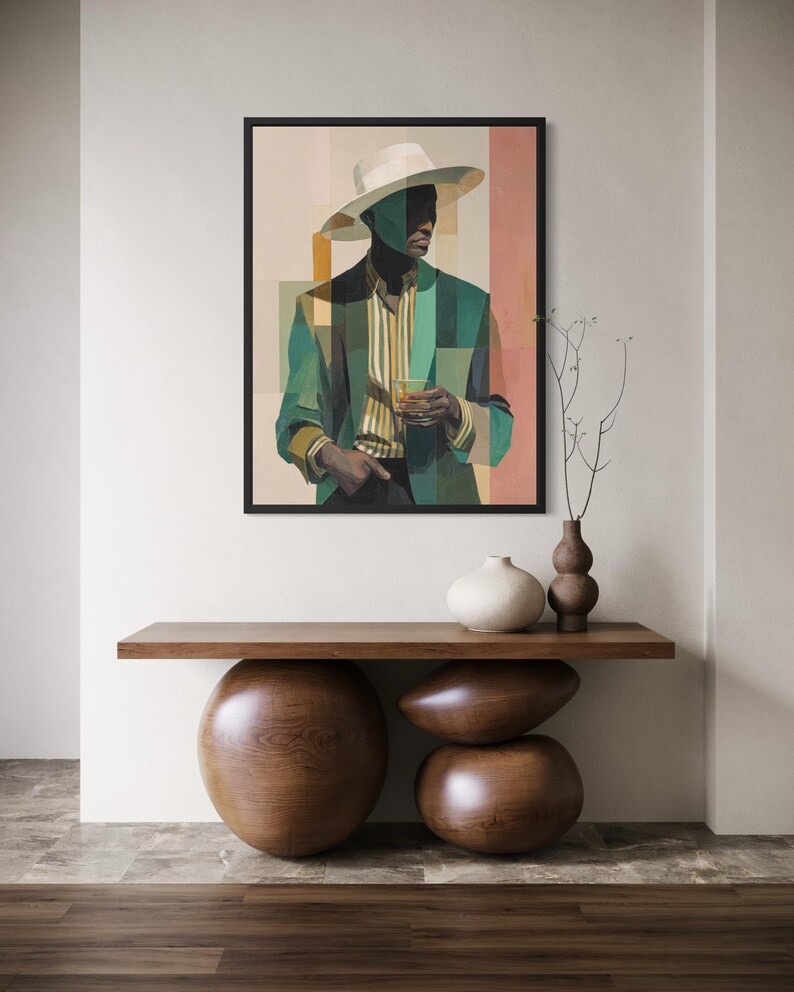 May include: A framed art print featuring a geometric portrait of a person in a hat and blazer, holding a drink. The artwork is in shades of green, beige, and pink. The print is displayed above a wooden console table with decorative wooden spheres and vases.