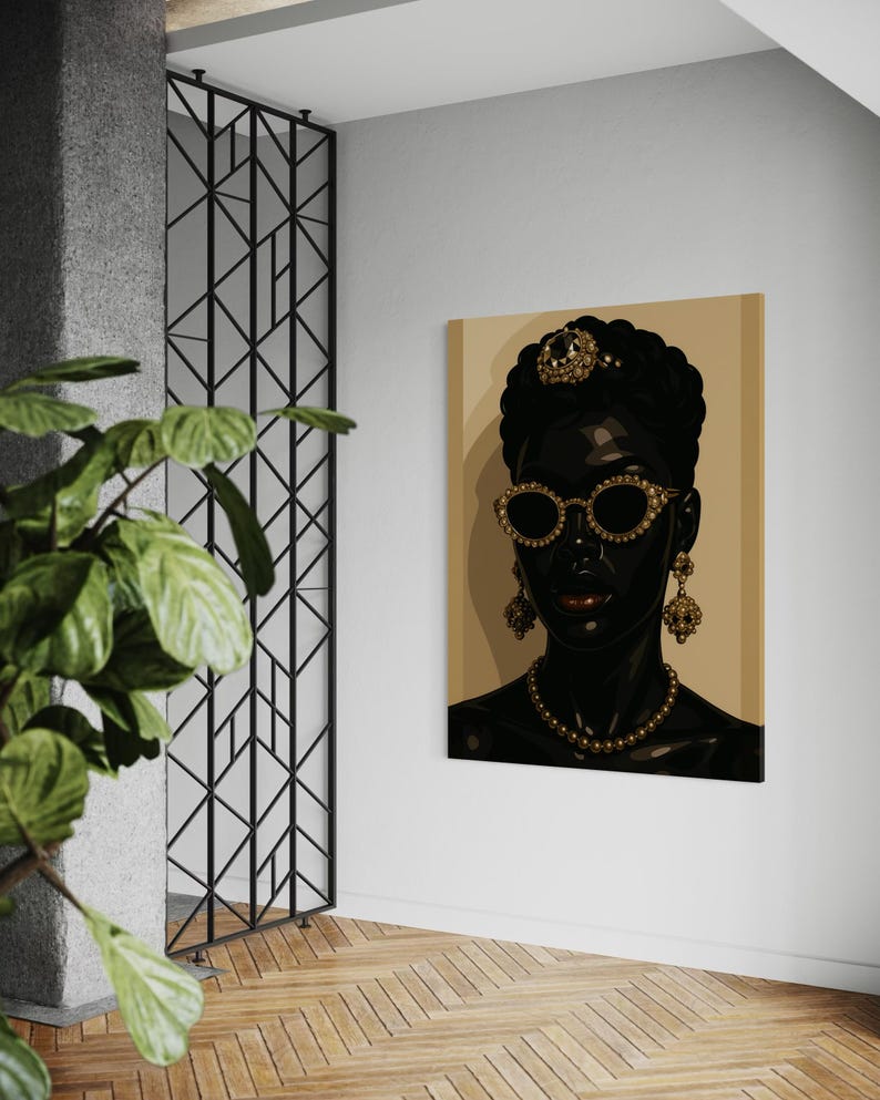 May include: A canvas art print featuring a stylized portrait of a Black person adorned with gold jewelry, including a crown, earrings, and a necklace. The person is wearing gold-rimmed sunglasses. The background is a light tan color.