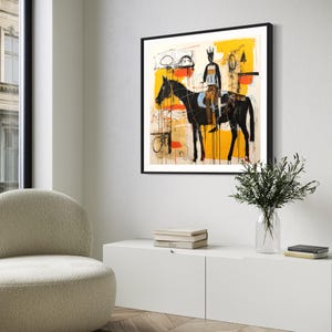 May include: Abstract art print depicting a black horse and rider set against a yellow and white backdrop. The artwork is framed in black and hangs on a white wall. The style is modern and expressive, suitable for home decor.