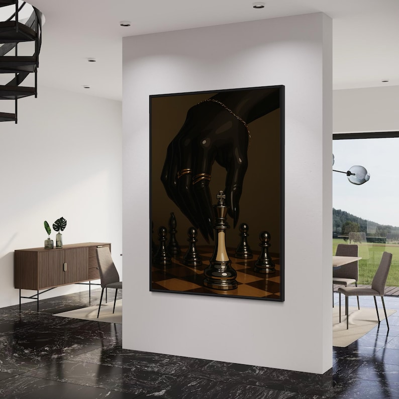 Op de afbeelding: Een ingelijste kunstdruk met een schaakspel. Een zwarte hand met gouden ringen en een armband zweeft boven het schaakbord, klaar om de witte koning te verplaatsen. Het kunstwerk heeft een donkere, dramatische esthetiek.