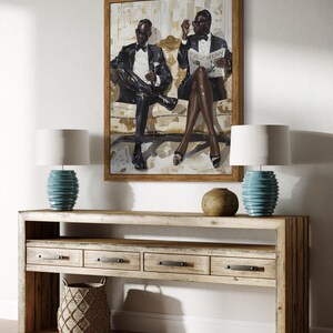 May include: A framed artwork depicts two figures in formal attire, seated on a sofa. Below, a light wood console table features drawers, a woven basket, and two turquoise lamps with white shades. A neutral rug completes the scene.