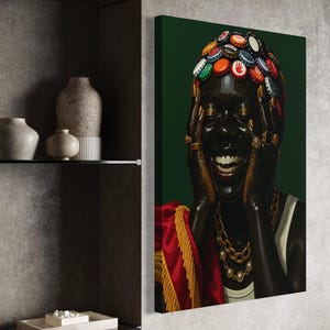 May include: A canvas print of a person with a dark complexion, adorned with bottle caps on their head and gold jewelry. The person is smiling, with hands on their face. A red and gold garment is draped over their shoulders against a dark green background.