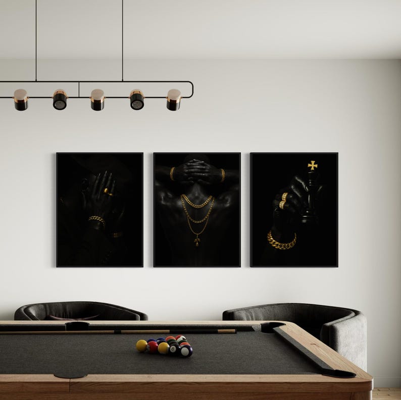 May include: Three black framed art prints. The prints feature close-ups of a person adorned with gold jewelry. One print shows hands covering the face, another shows hands behind the head, and the last shows a hand holding a chess piece.