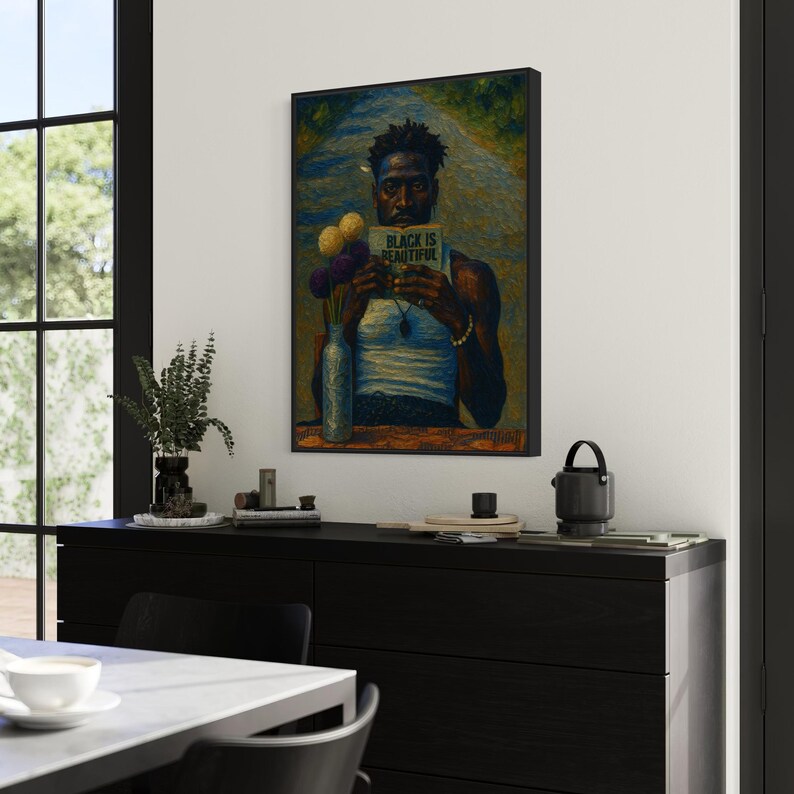 Puede incluir: Una obra de arte enmarcada que presenta un retrato de una persona negra sosteniendo un libro con el texto "BLACK IS BEAUTIFUL". La obra de arte se exhibe en una pared sobre un mueble negro. Un jarr&oacute;n con flores y otros objetos decorativos est&aacute;n en el mueble.