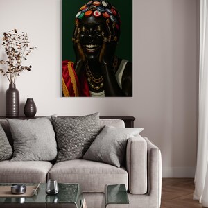 May include: A canvas art print features a person with dark skin, adorned with bottle caps on their head and gold jewelry. The person is laughing, with hands near their face. The background is a deep green, and the person is wearing a white top and a red and gold shawl.