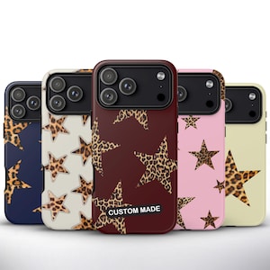 Pode incluir: Uma coleção de cinco capas de telefone com desenhos de estrelas e estampas de leopardo. As capas vêm em azul marinho, creme, bordô, rosa e amarelo pálido. A capa bordô tem o texto "CUSTOM MADE" em um retângulo branco.