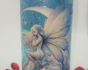 May include: A blue glitter tumbler featuring a crescent moon with a fairy sitting on it. The fairy has long blonde hair and is wearing a white dress. The tumbler has a blue lid.