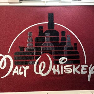 Könnte beinhalten: Gestickte Darstellung einer Burg Silhouette mit Flaschen Alkohol im Inneren, mit dem Text "Malt Whiskey" darunter.