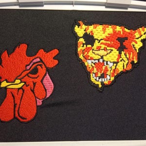 May include: Two embroidered patches, one of a red rooster with a yellow beak and the other of a yellow and red tiger with a bloody mouth.