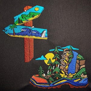 May include: Embroidered patches featuring outdoor themes. One patch depicts a directional sign with mountain and ocean scenes. The other patch shows a hiking boot with a waterfall, trees, and a sun.