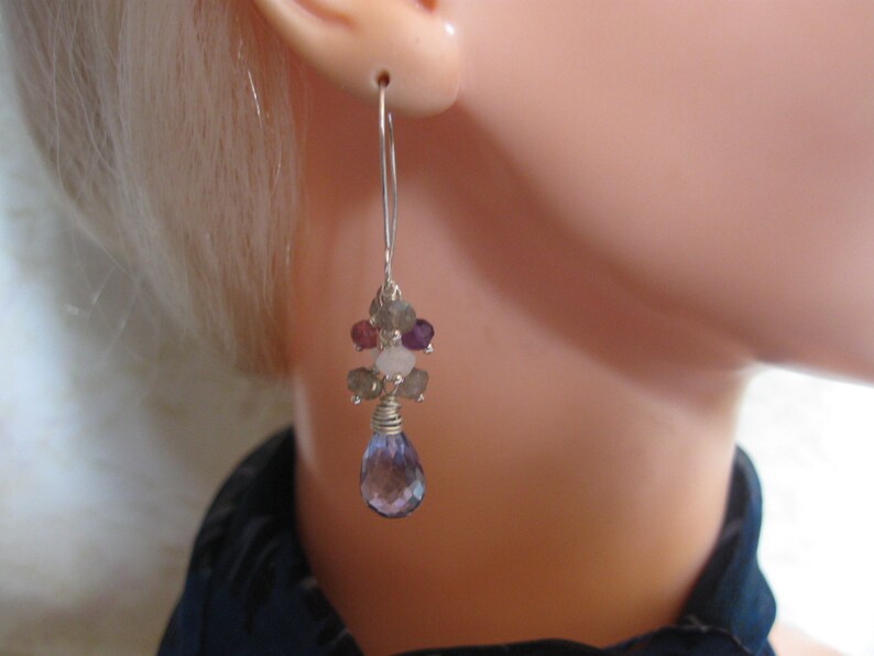 May include: Silver dangle earrings with a cluster of amethyst, rose quartz, and labradorite gemstones. The earrings have a teardrop-shaped amethyst gemstone hanging from the bottom.