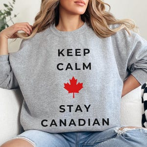 May include: Gray sweatshirt with the text "Keep Calm Stay Canadian" and a red maple leaf graphic.