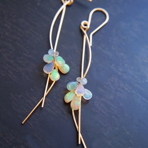 These earrings features iridescent ethiopian opal smooth drops are wire wrapped with wavy wire. These unique earrings add a touch of feminine charm to just about any outfit.