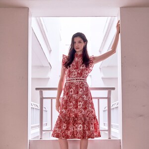 Lady wearing a red and white batik cheongsam dress