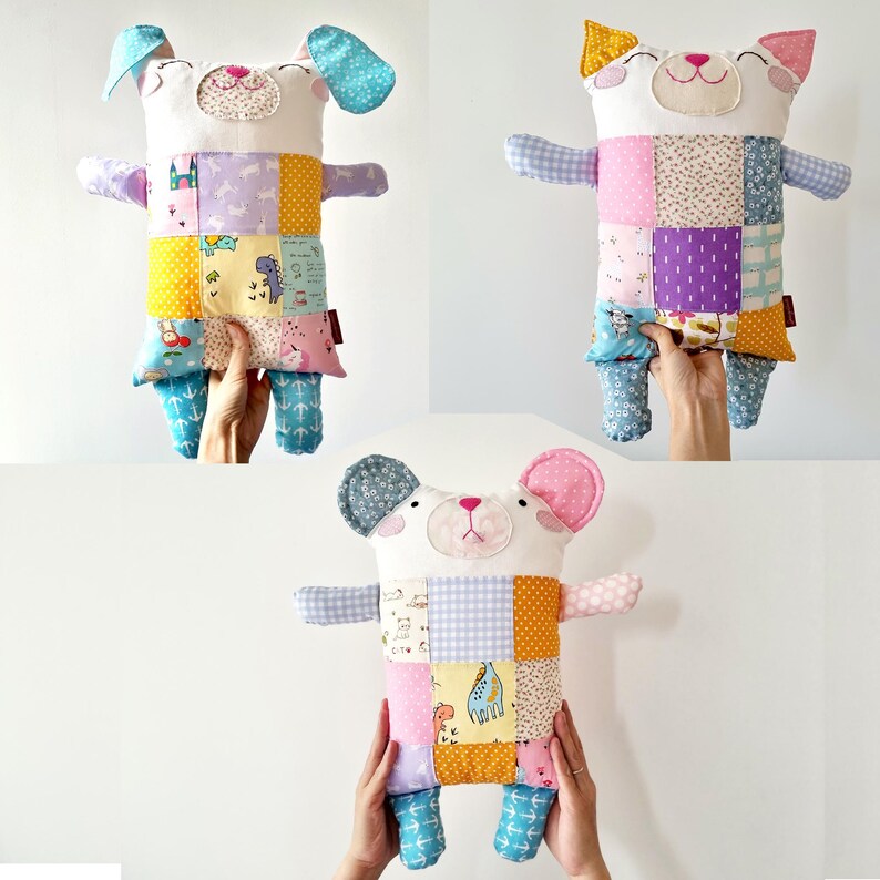 May include: Three handmade stuffed animal toys: a dog, a cat, and a mouse. Each has a white face and body with patchwork fabric details in various colours and patterns. The dog has blue ears, the cat has yellow ears, and the mouse has pink ears.