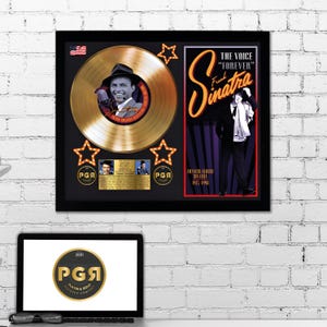 Peut inclure: Un disque d'or dans un cadre noir. Le disque est un disque d'or avec une photo de Frank Sinatra au centre. Le cadre a un fond noir avec une image rouge et blanche de Frank Sinatra et le texte "The Voice "Forever" Frank Sinatra". Le cadre a également deux étoiles dorées et le texte "PGA Platinum & Gold Records Company" en lettres dorées.