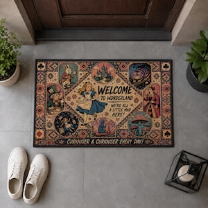 Puede incluir: Un felpudo rectangular con temática de Alicia en el país de las maravillas, una ilustración central de Alicia y el texto Welcome to Wonderland We're all a little mad here y Curiouser & Curiouser every day rodeado de varias viñetas de personajes.