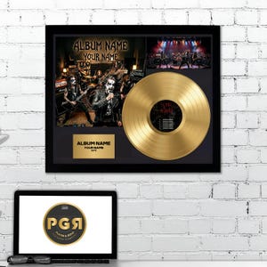 May include: A framed display featuring a gold vinyl record, a band photograph, and a gold plaque with the text ALBUM NAME, YOUR NAME, and DATE. The record label includes the text YOUR ALBUM and a tracklist. The frame is black with a dark mat.