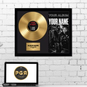Può includere: Un disco d'oro incorniciato con un vinile color oro, una fotografia in bianco e nero di un artista e una targa dorata con il testo ALBUM NAME, YOUR NAME e DATE. L'etichetta centrale del disco riporta la scritta YOUR ALBUM.