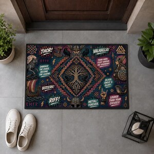 May include: A rectangular doormat featuring a dark blue background with a central Yggdrasil tree design. It includes illustrations of a Viking, a longship, ravens, and a helmet, with text including THOR!, VALHALLA!, and EMBRACE THE CHAOS.