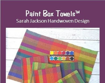 May include: Four colorful handwoven towels in a variety of colors, including red, orange, yellow, green, blue, and purple. The towels are arranged in a stack on a white wooden surface. The towels are labeled "Paint Box Towels" and "Four Colorful Towels Four Shafts".