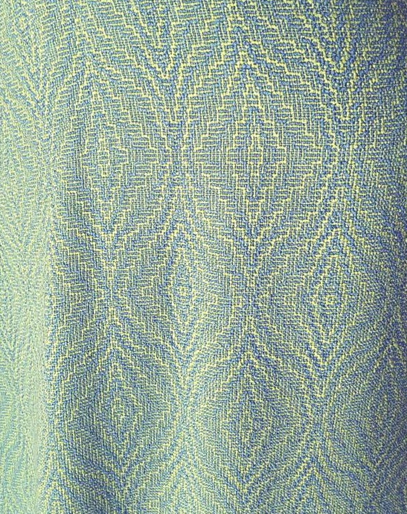 May include: A close-up of a blue and yellow patterned fabric with a subtle diamond pattern.
