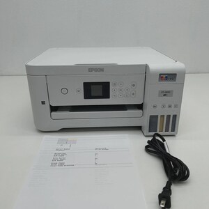 May include: A white Epson ET-2850 printer with a control panel, ink tanks, and a paper tray. A sheet of printed paper and a black power cord are in front of the printer. The Epson logo is visible.