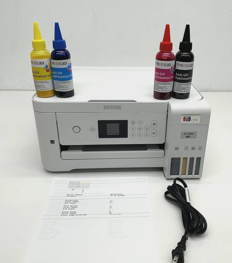 May include: A white Epson ET-2850 printer with four ink bottles in yellow, blue, red, and black. The ink bottles are labelled "Anti-UV Sublimation Ink". A printed sheet of paper and a black power cable are also present.
