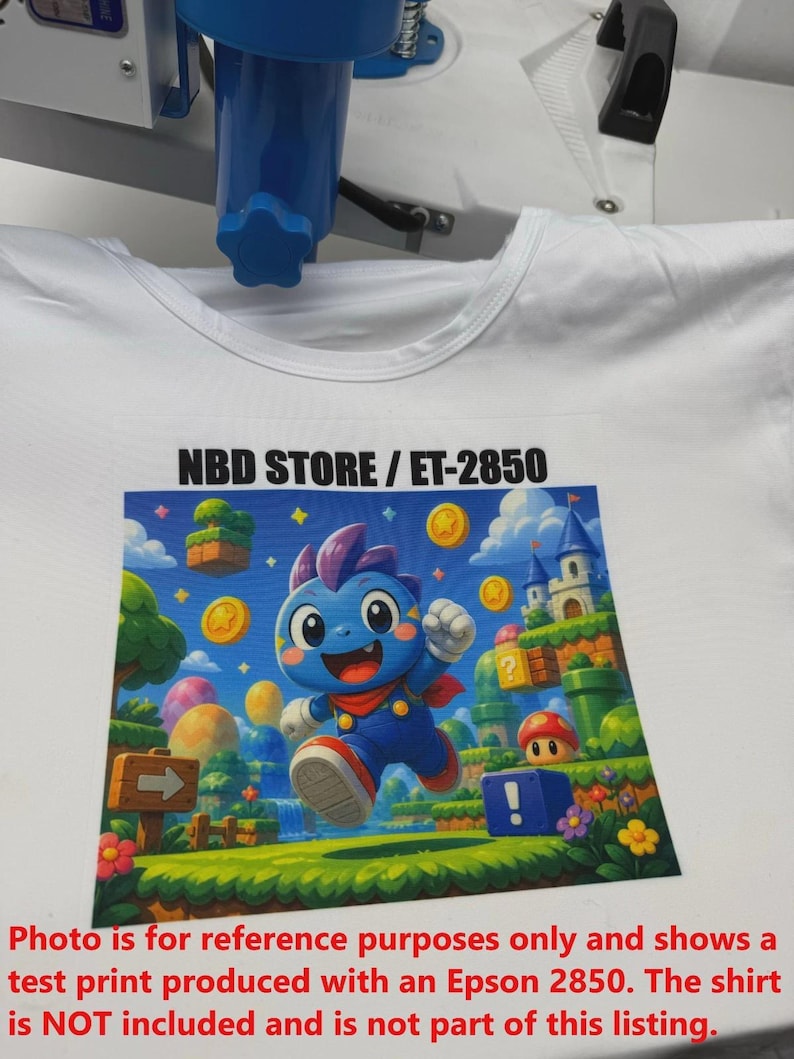 May include: White t-shirt with a vibrant graphic print of a blue cartoon character in a video game scene. The design includes coins, a castle, and the text "NBD STORE / ET-2850".