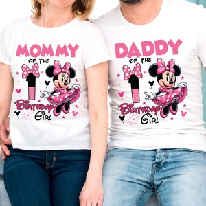 May include: White t-shirts with matching Minnie Mouse designs. One shirt reads "MOMMY of the Birthday Girl" and the other reads "DADDY of the Birthday Girl". Each shirt features a pink Minnie Mouse graphic and the number 1.