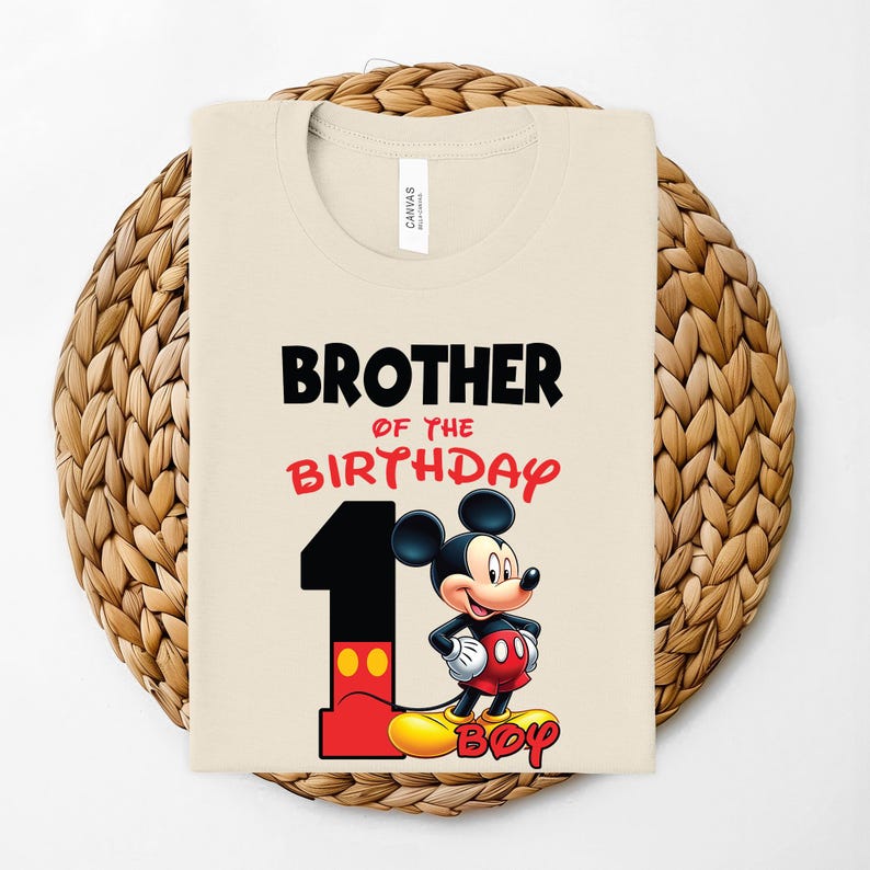May include: A beige t-shirt with the text "BROTHER OF THE BIRTHDAY" in black and red. A large number "1" is on the left, with Mickey Mouse standing next to it. The word "BOY" is at the bottom in yellow.